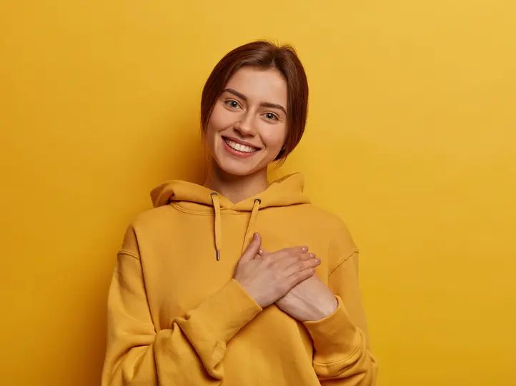 Дівчина з усмішкою та рукою на серці — атмосфера довіри у школі