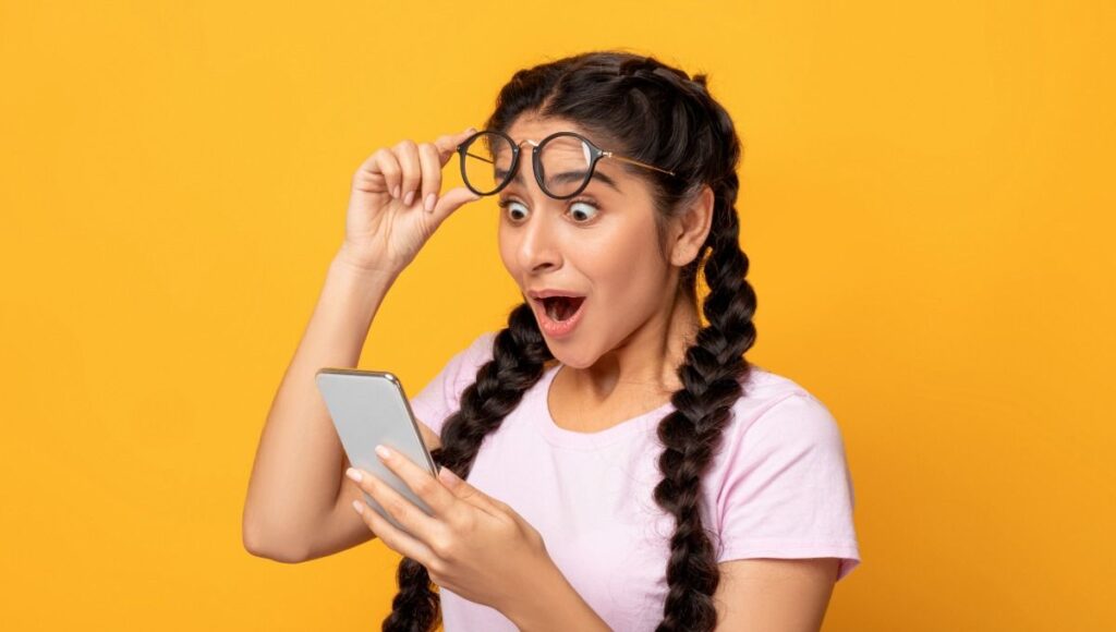 Дитина здивовано дивиться на телефон — школа Монтессорі