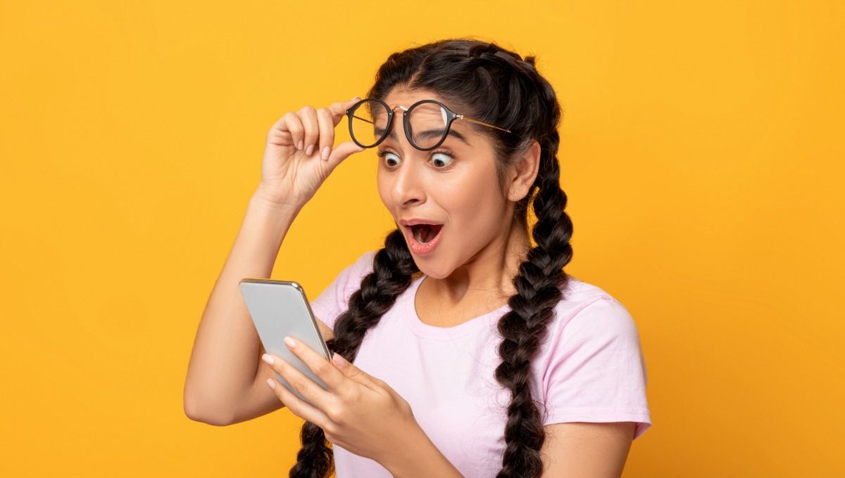 Дитина здивовано дивиться на телефон — школа Монтессорі