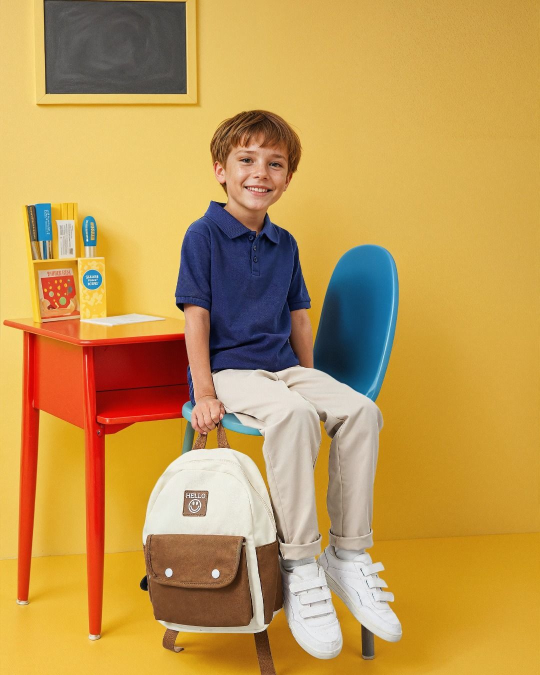 Усміхнений хлопчик з рюкзаком біля парти, інклюзивна школа та комфортне навчальне середовище