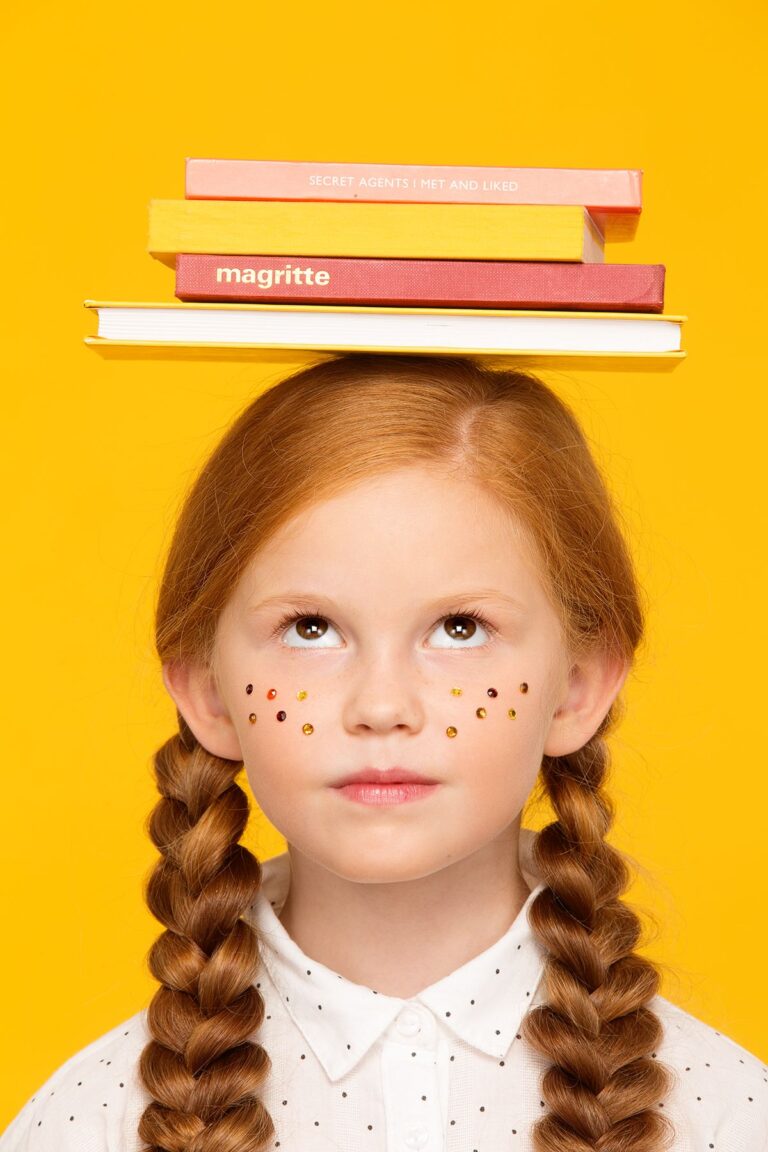 Дівчинка з книжками на голові символізує підготовку до навчання за кордоном