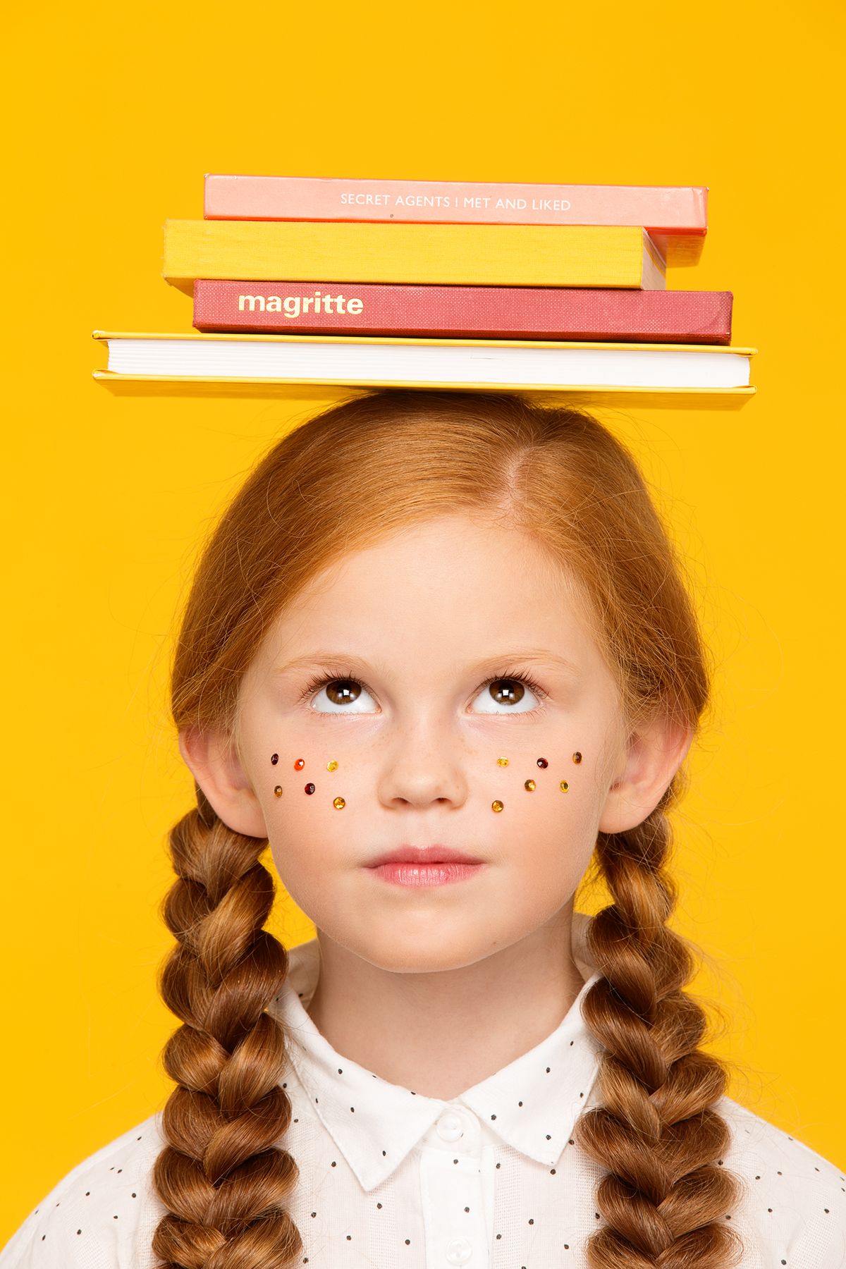 Дівчинка з книжками на голові символізує підготовку до навчання за кордоном